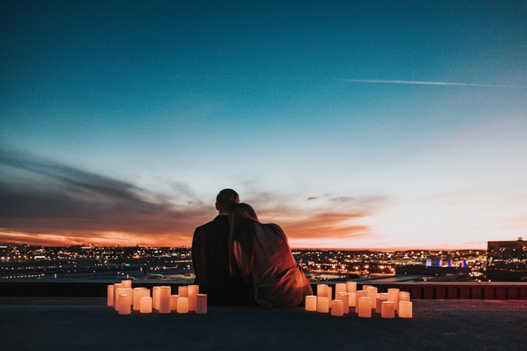 couple-sitting-on-the-field-facing-the-city-edulzpoksue